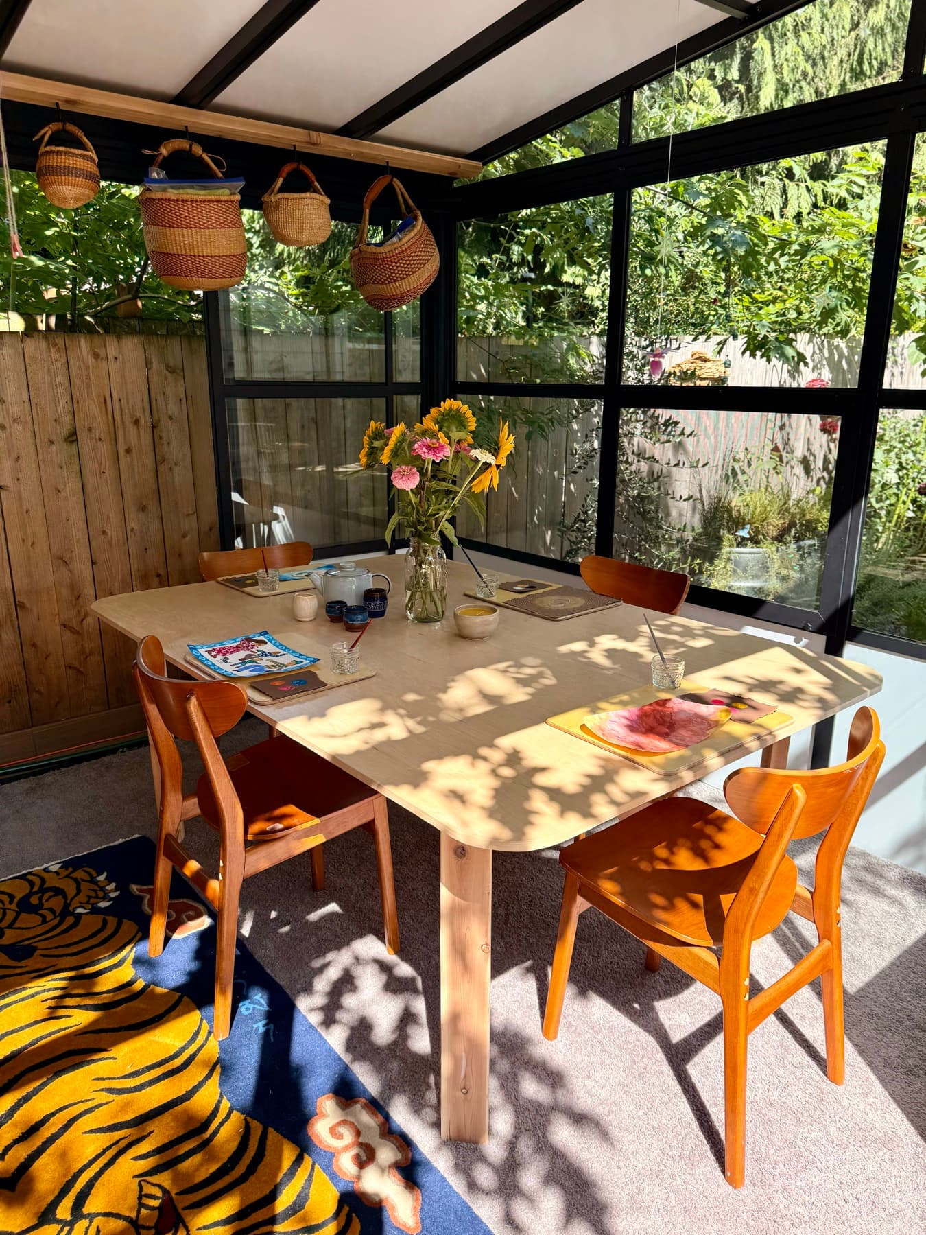A sunlit studio table set with tea, sunflowers, and materials ready for class
