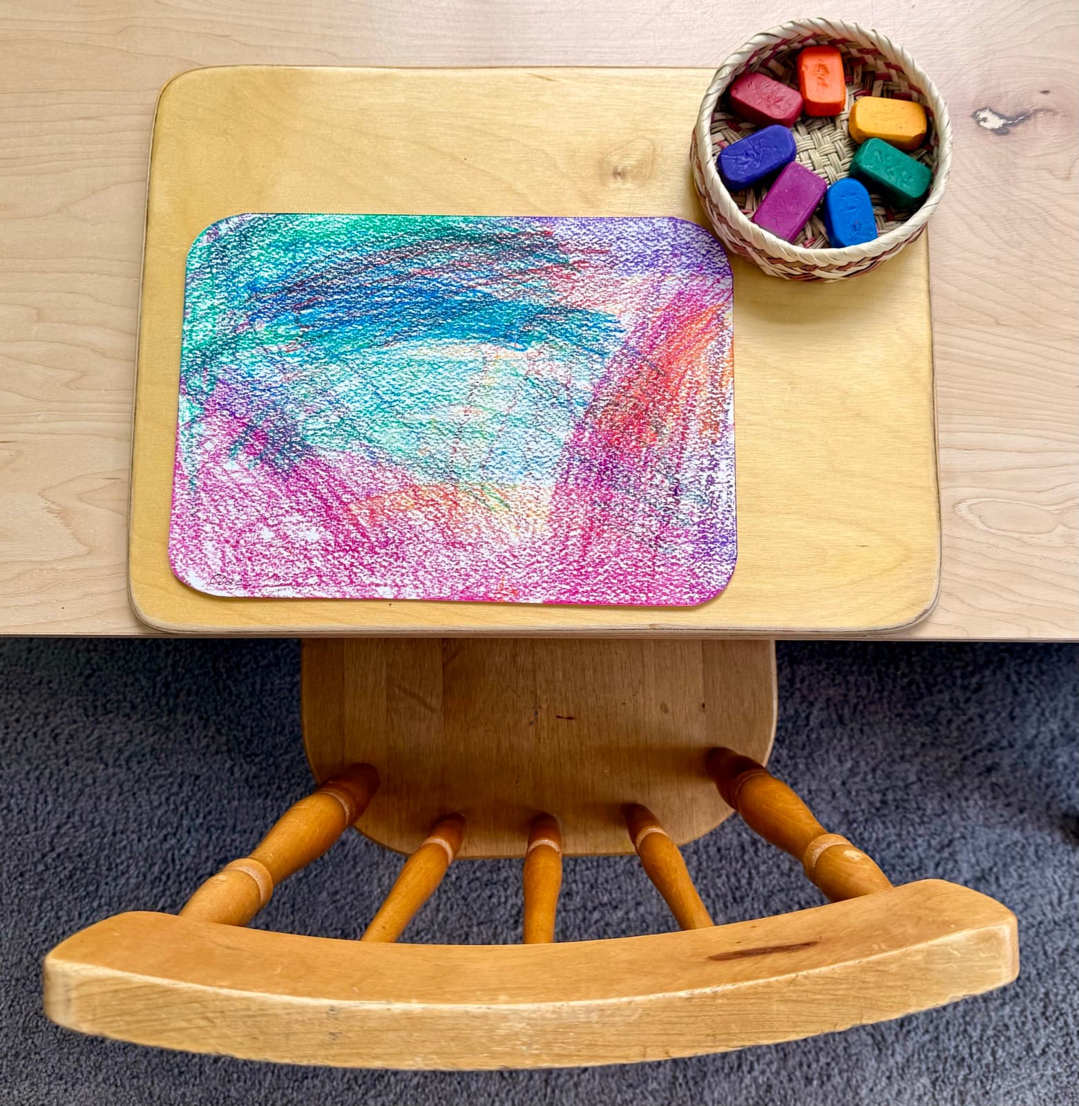 A finished crayon drawing with a basket of beeswax crayons